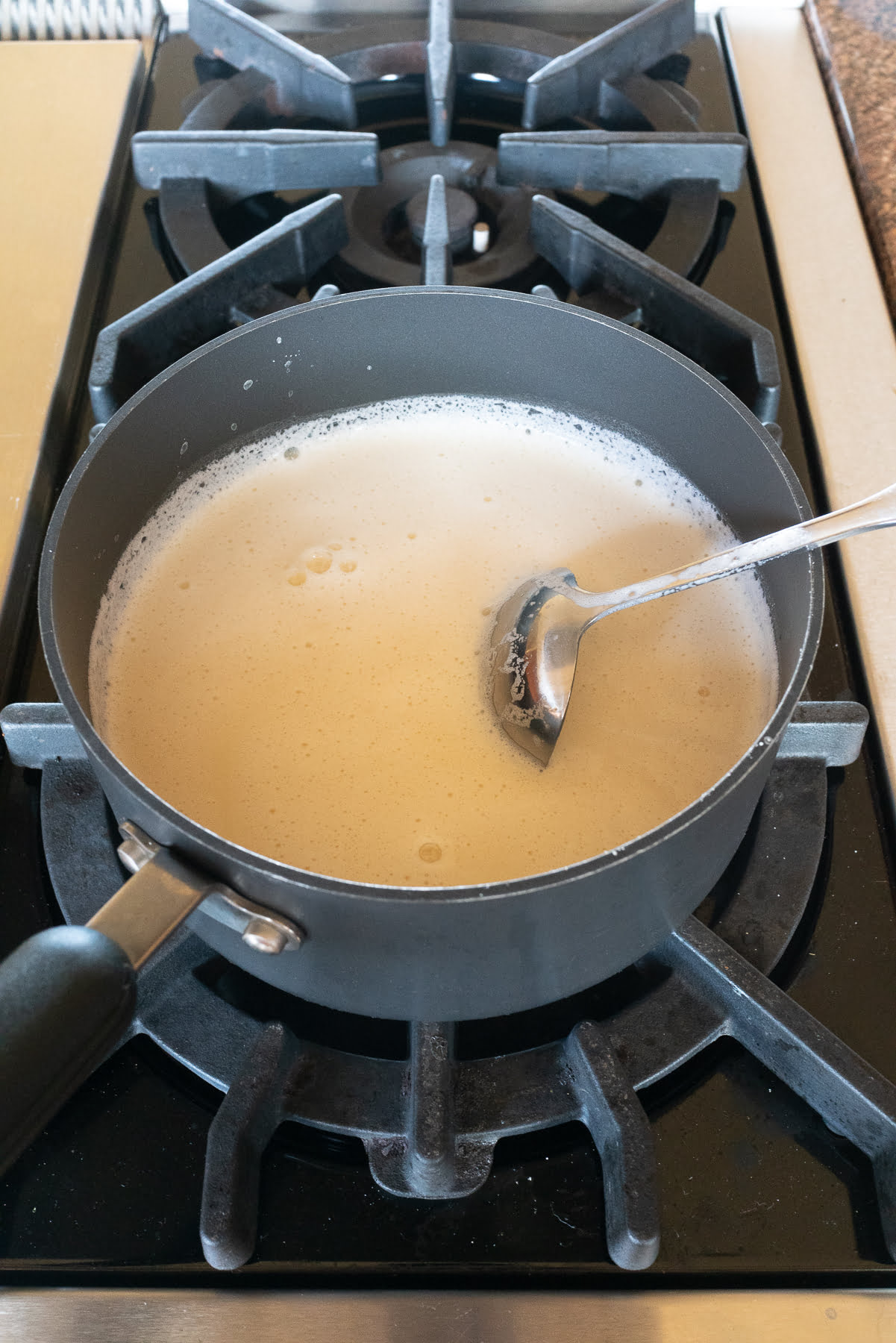 Heading up homemade soy milk on the stove in a pot.