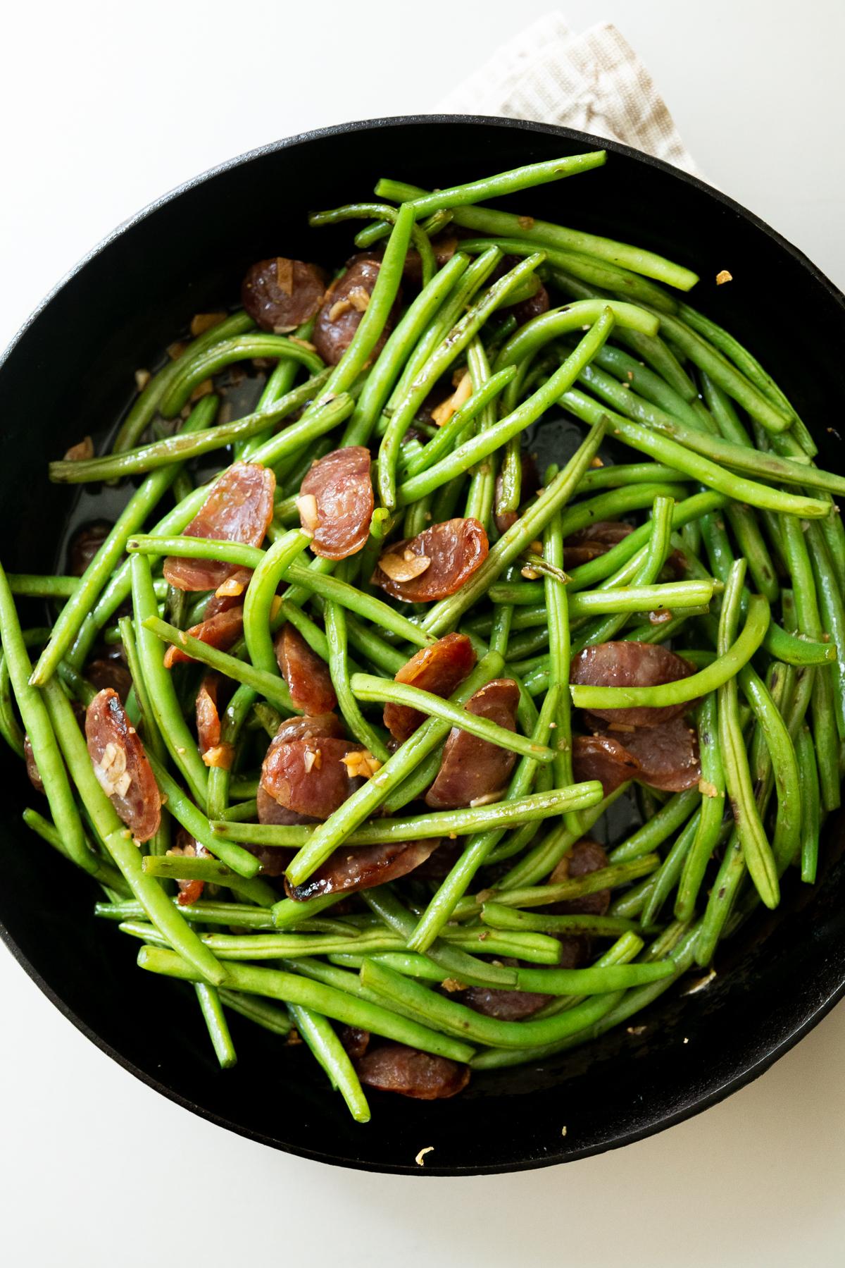 Chinese sausage and green beans in a cast iron pan, just finished cooking