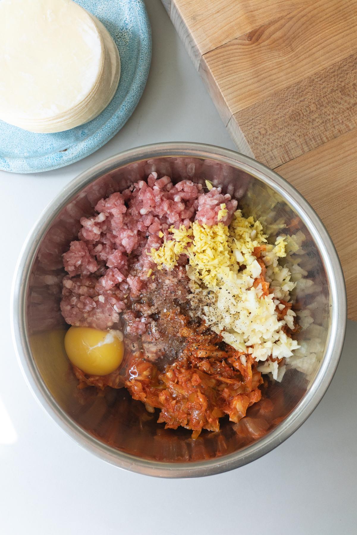 filling ingredients for kimchi dumplings in a mixing bowl