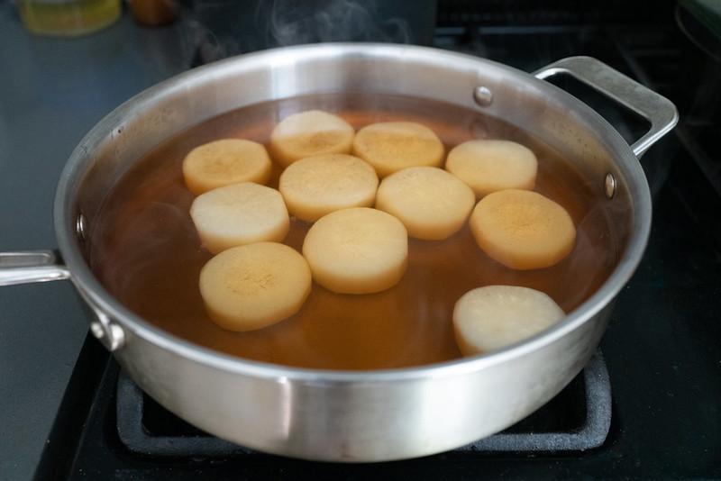 Simmering the daikon over the stove in a dashi-based broth