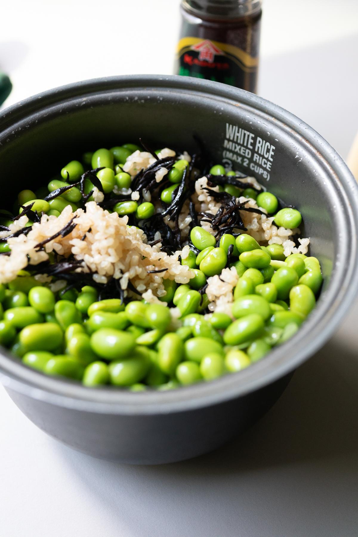 Mixing edamame into the cooked rice and hijiki