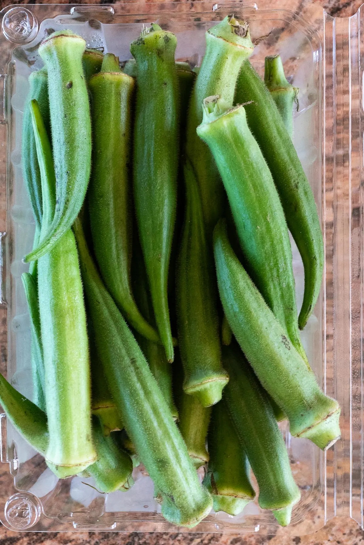 A container of fresh, raw, okra.