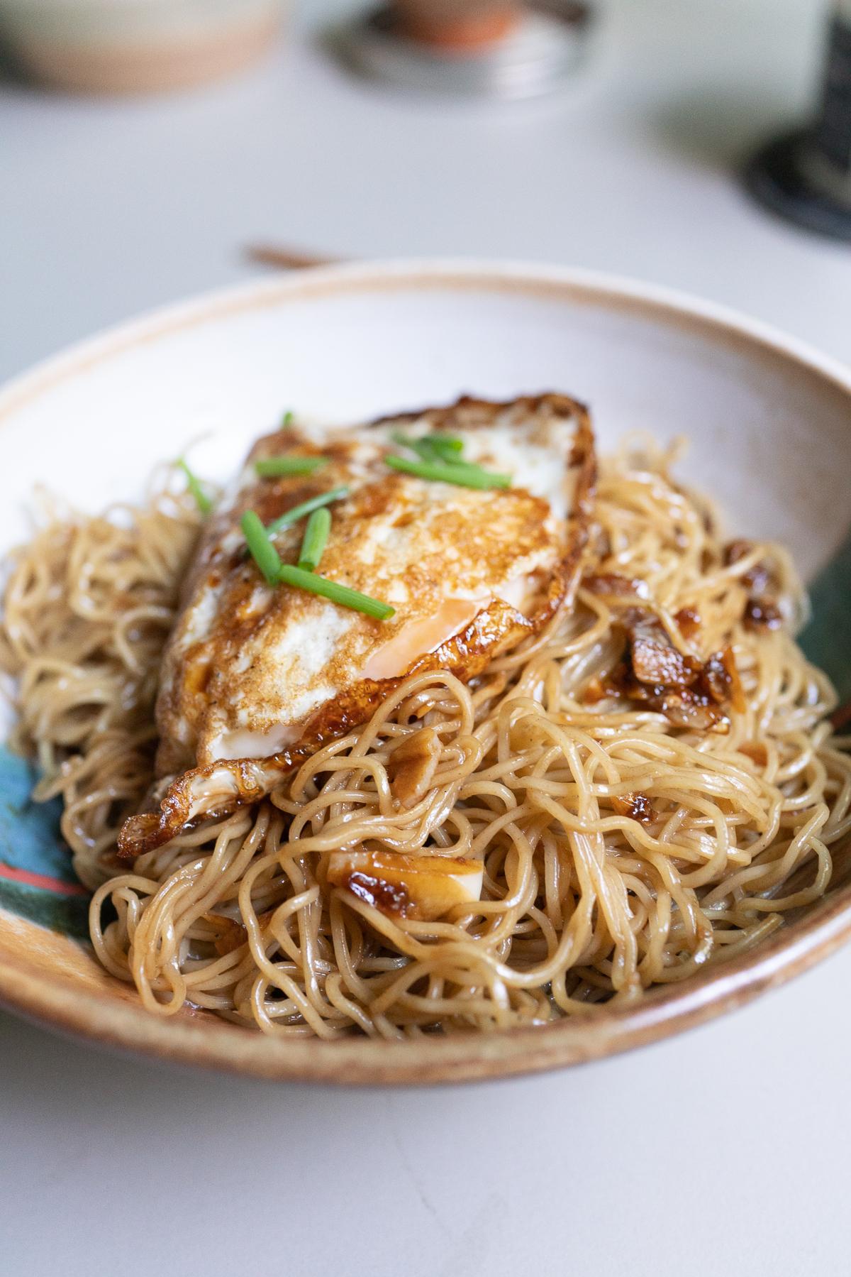 A bowl of Gon Lo Mein topped with a Pocket Egg