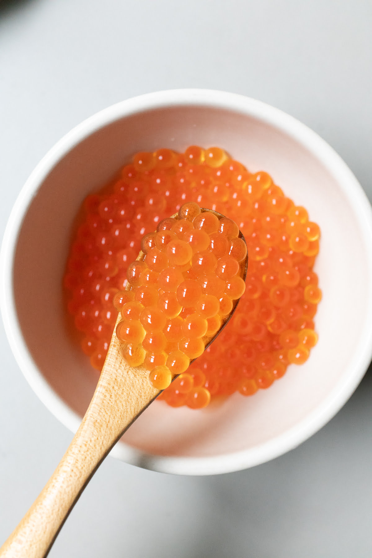 A spoonful of salt-cured salmon roe in a bowl