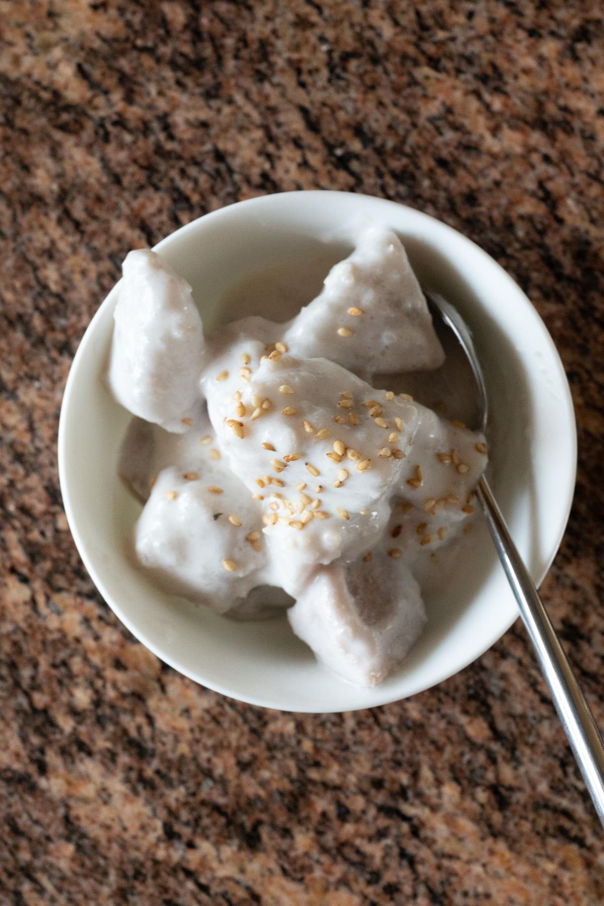 A bowl of Taro with Coconut Milk, topped with sesame seeds.