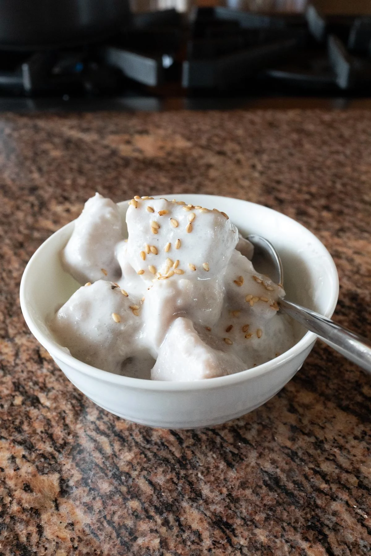 A bowl of Taro with Coconut Milk, topped with sesame seeds.