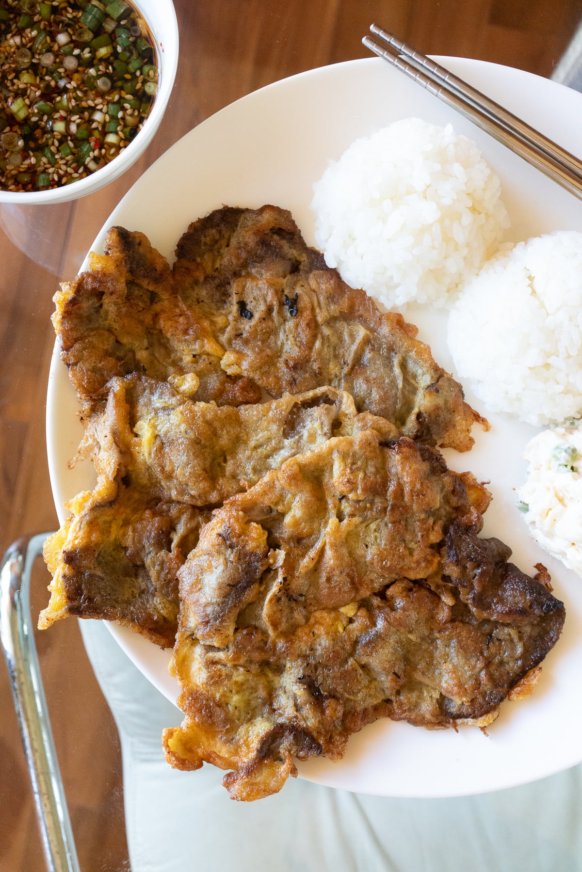 A plate of meat jun with rice and Mac salad.