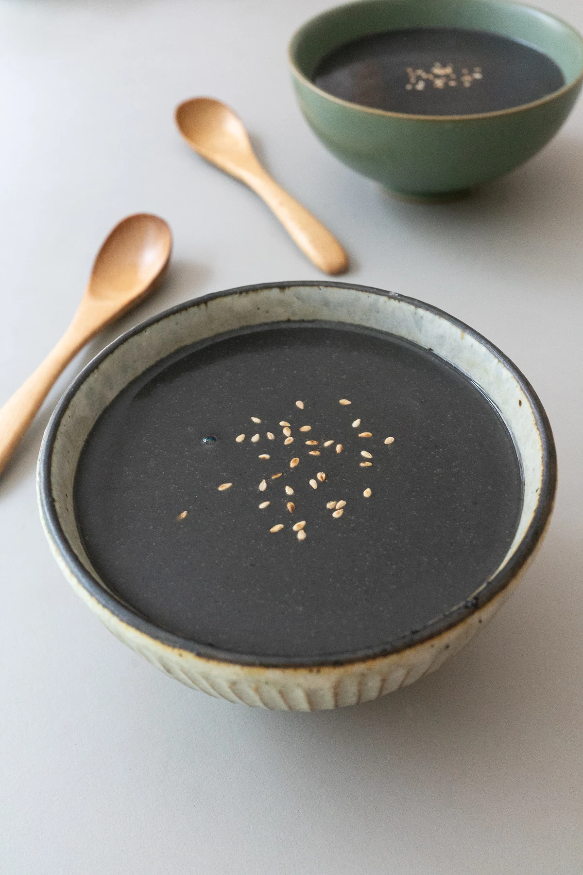 Bowl of Black Sesame Soup, topped with white sesame seeds.