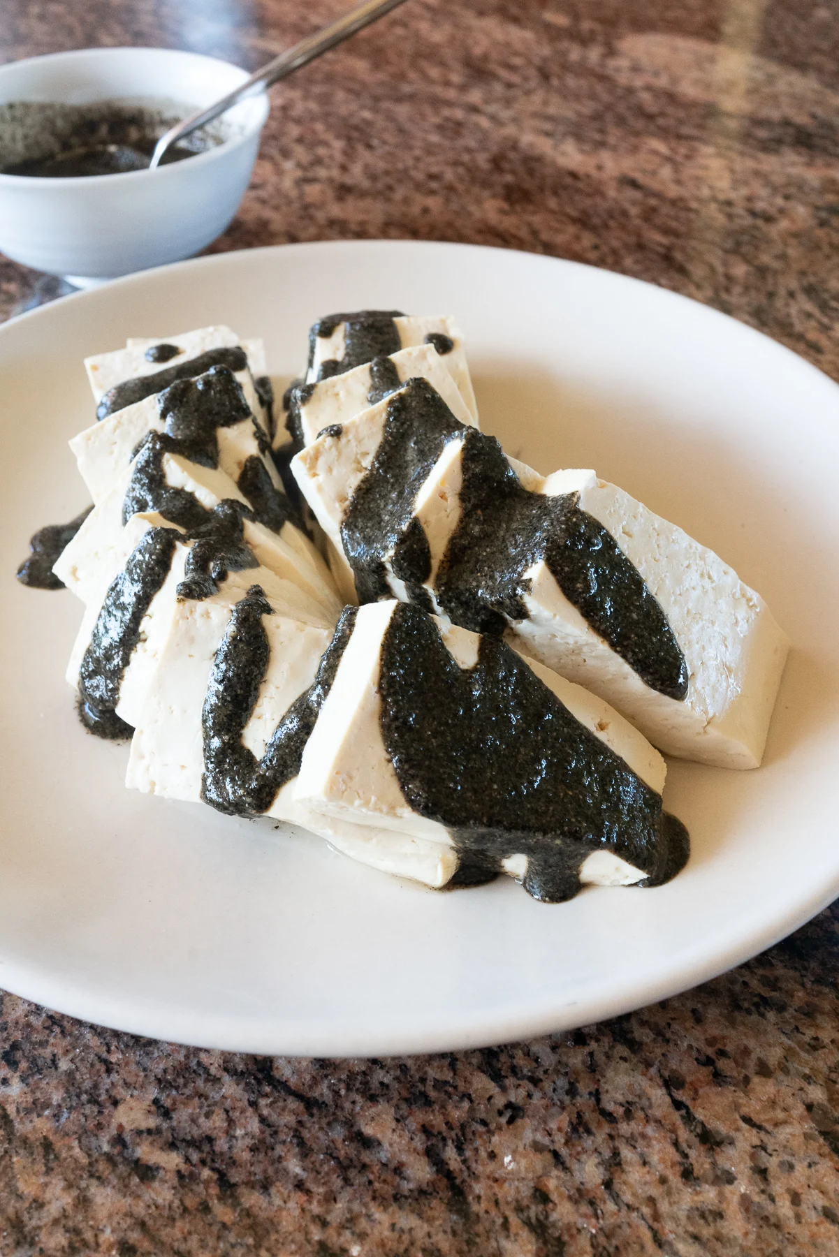 A prepared dish of Black Sesame Sauce On Steamed Tofu
