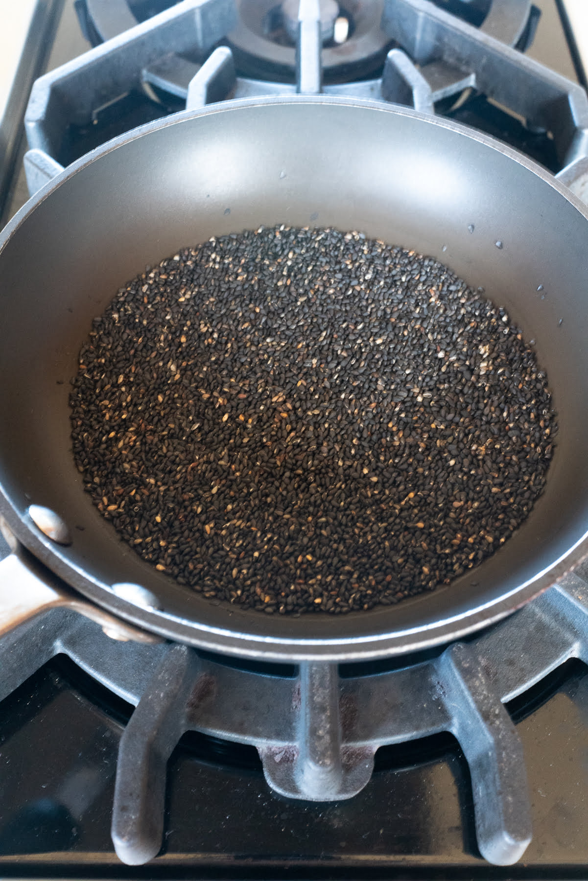 Toasting the roasted black sesame seeds on the sove.