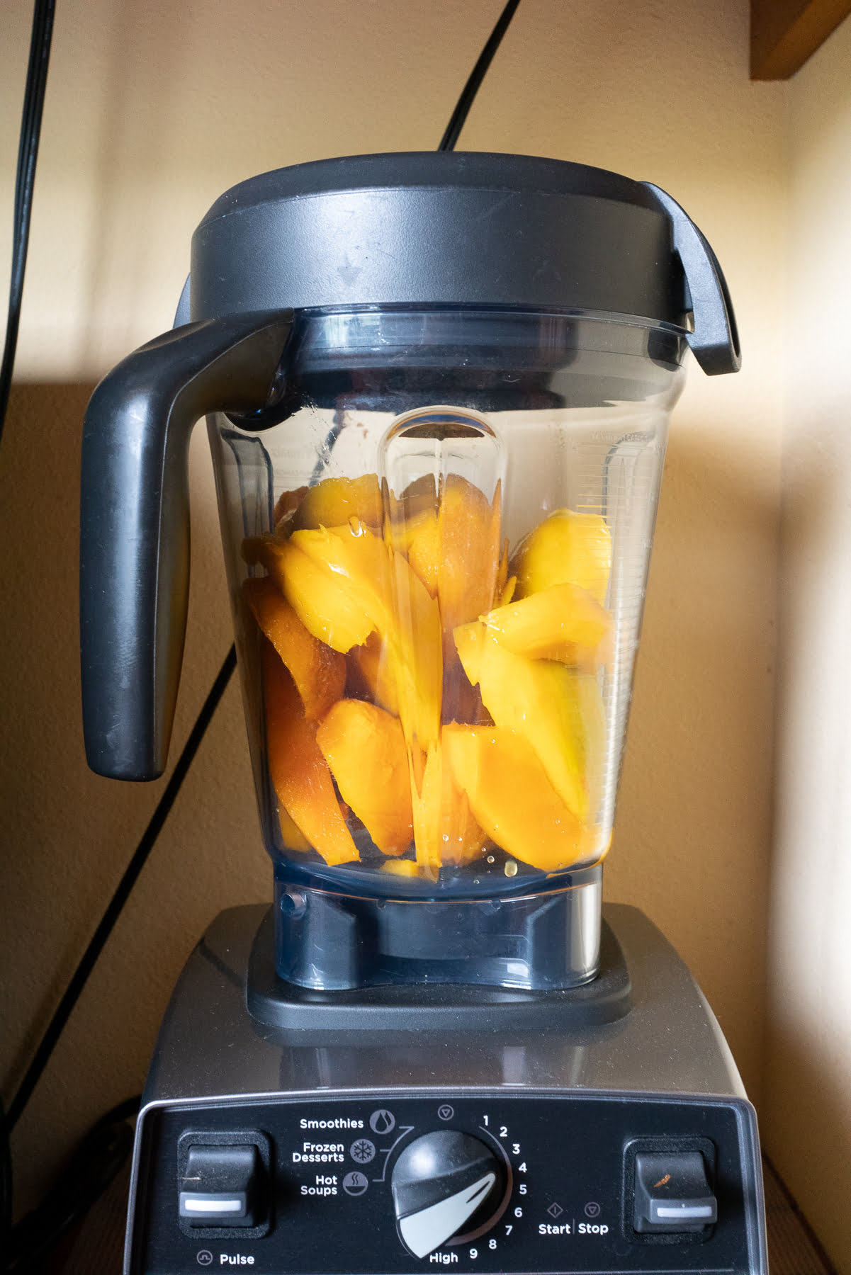 Blending fresh mangos to make mango puree.