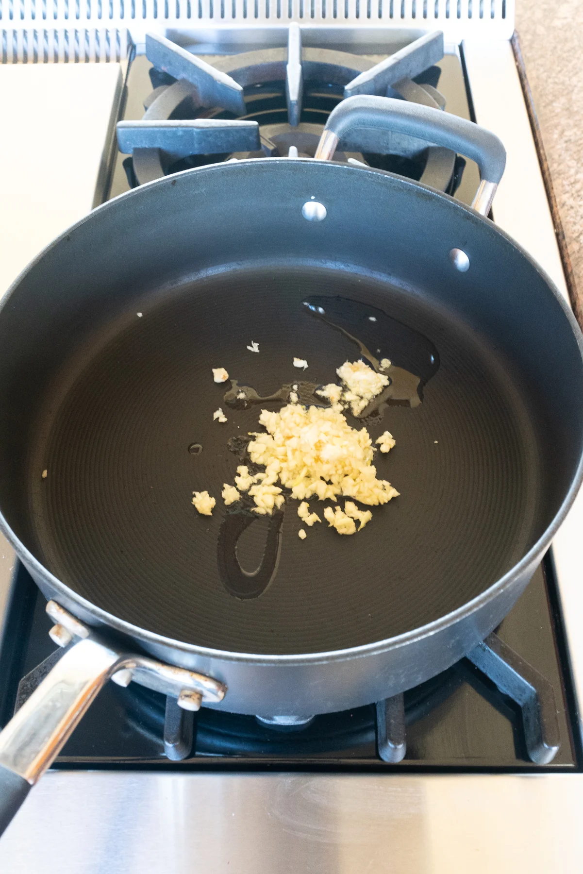 Sautéing minced garlic in a pan.