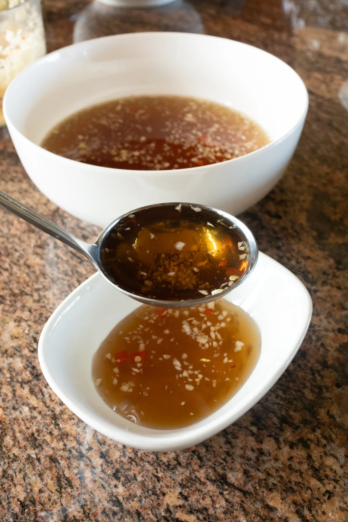 Spooning the Nuoc Cham / Nuoc Mam (Vietnamese Fish Sauce Dipping Sauce) into individual bowls for dipping.