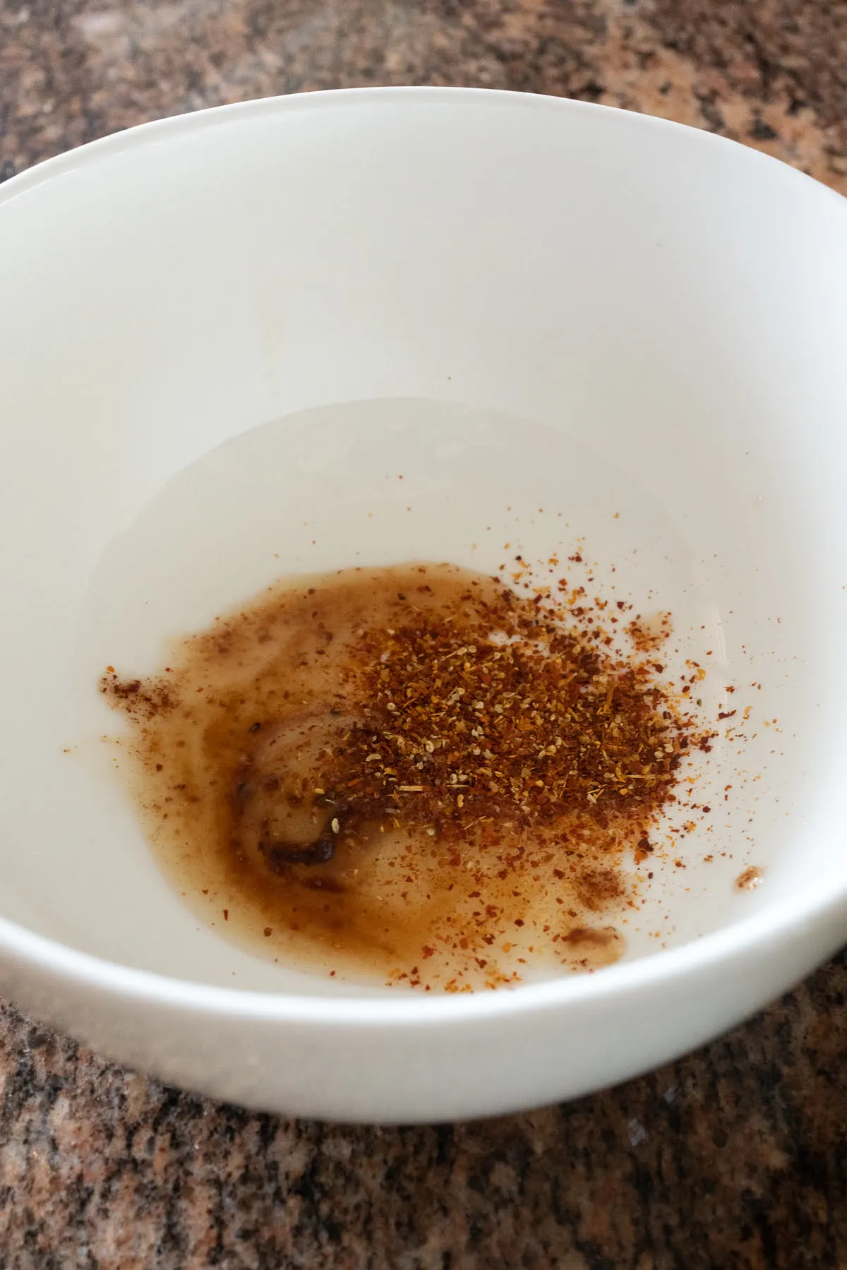 Adding the oil packet and chili powder packet to a bowl.