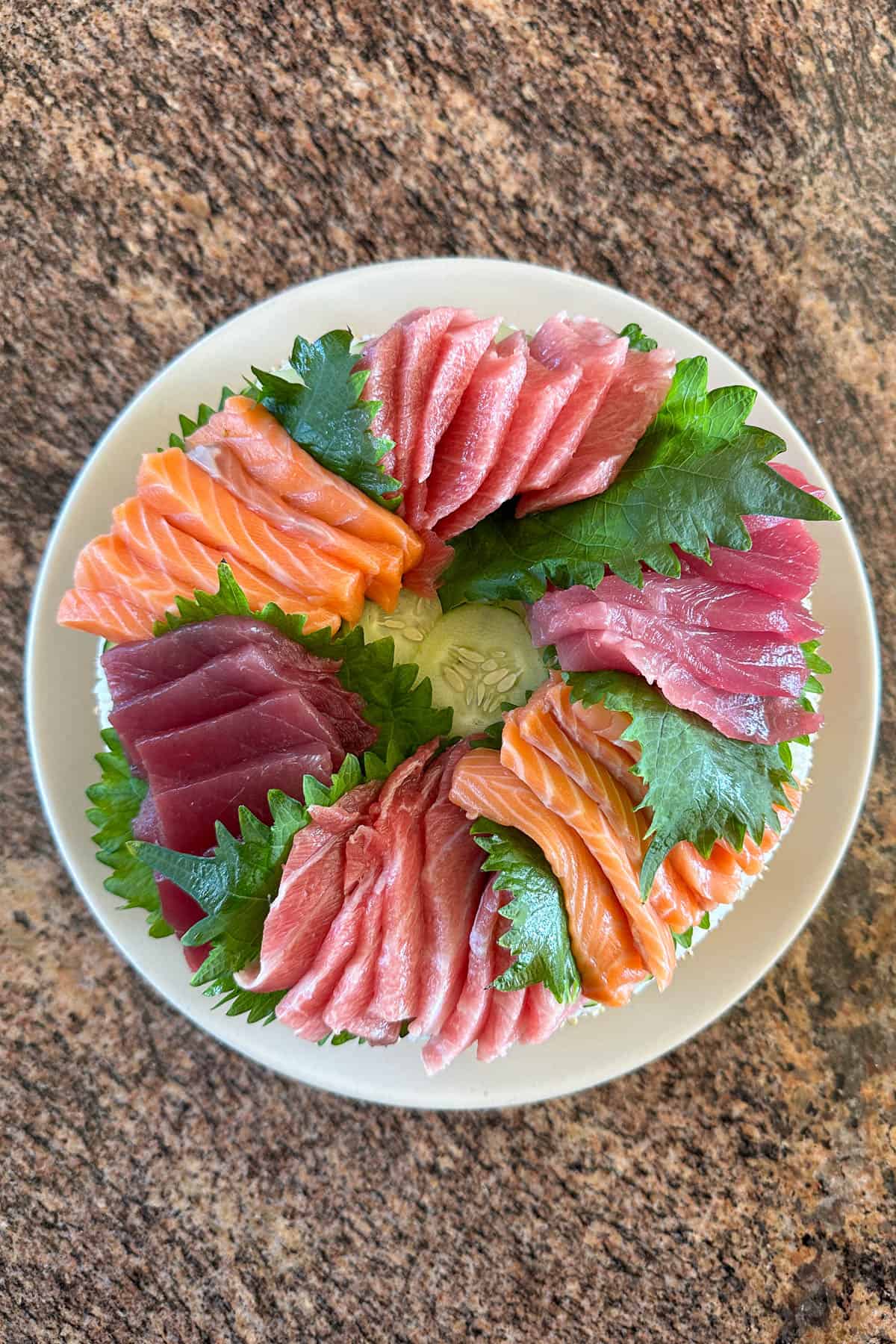 Adding sashimi to the sushi cake.