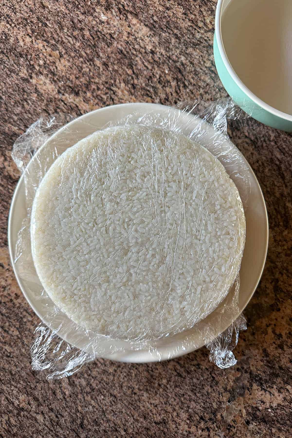 Flipping the sushi cake base over and removing the pan.