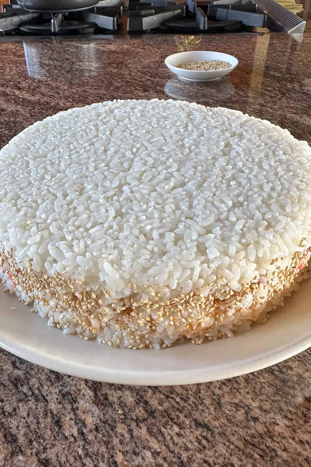 Adding sesame seeds to the sushi cake