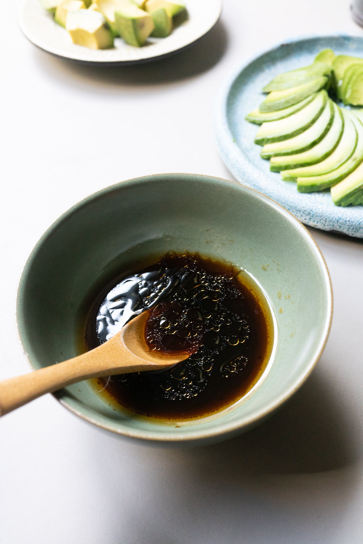 The dressing for Japanese avocado salad in a bowl (a mixture of rice vinegar, soy sauce, and sesame oil).