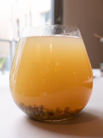 A glass of mung bean drink, served warm.