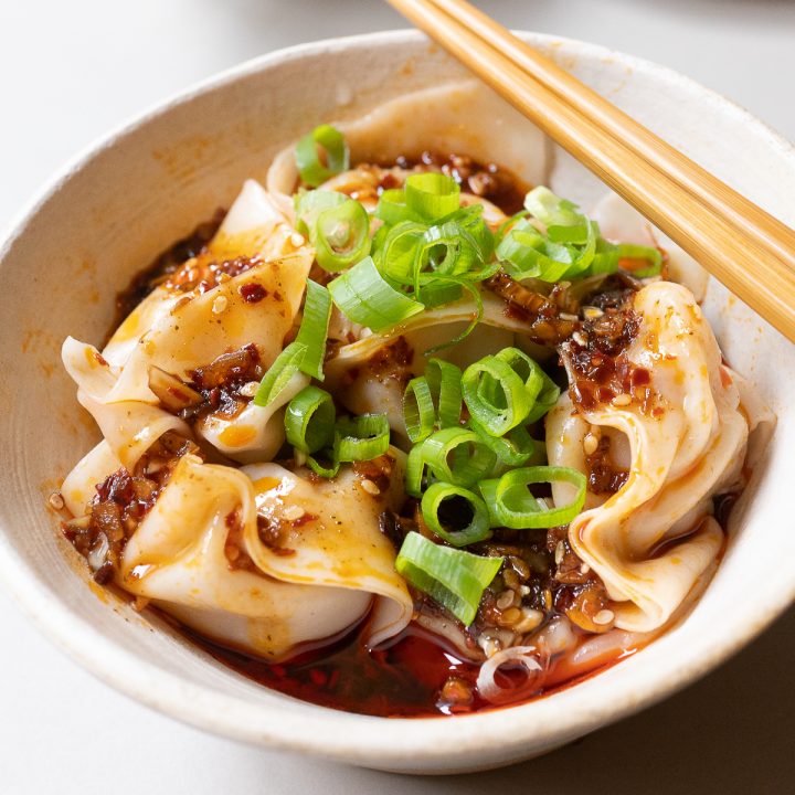A bowl of spicy wontons, ready to eat.