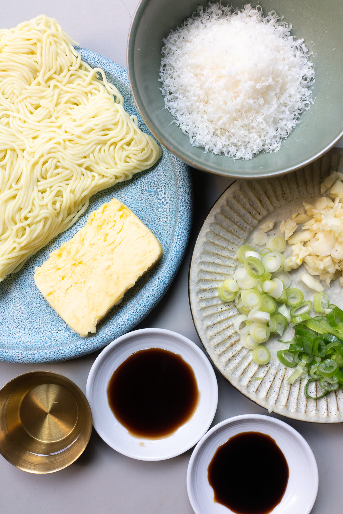 Ingredients for garlic noodles: yakisoba, butter, parmesann, garlic, green onions, mirin, soy sauce, and Maggi sauce.