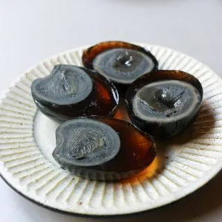 Two peeled and halved century eggs on a plate.