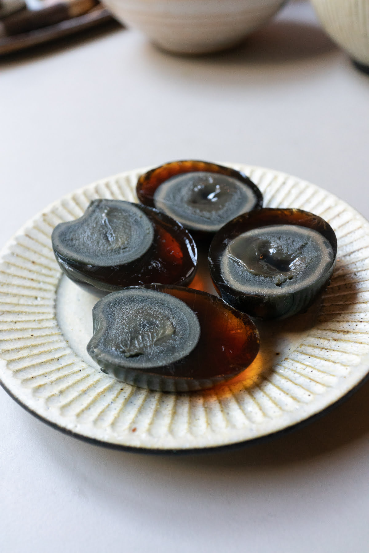 Two peeled and halved century eggs on a plate.