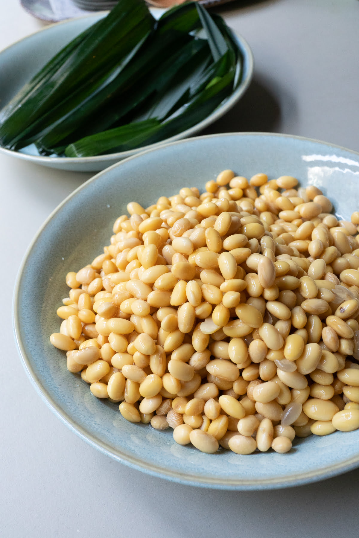 A plate of soybeans and pandan leaves.