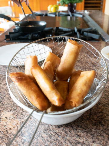 A batch of banana lumpia straight from the fryer, hot and fresh.