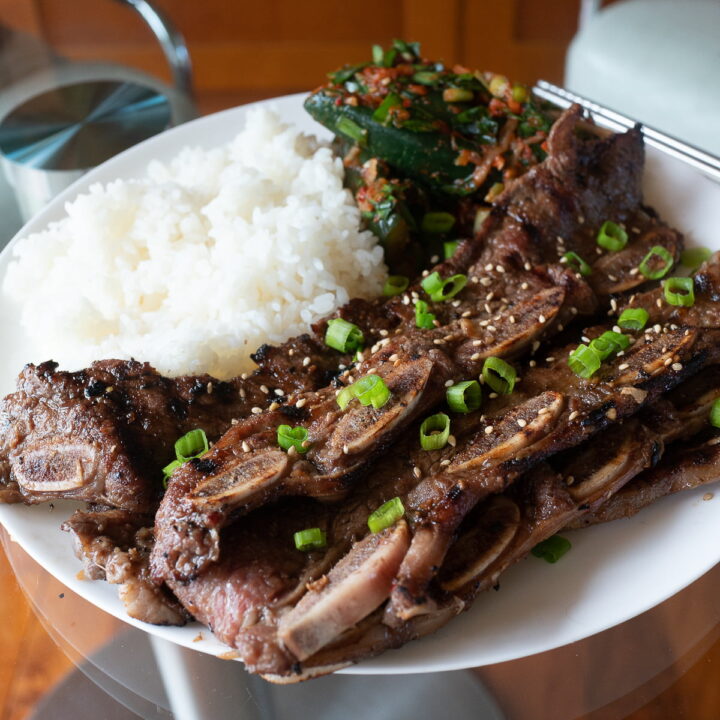 A plate of kalbi with rice and kimchi.
