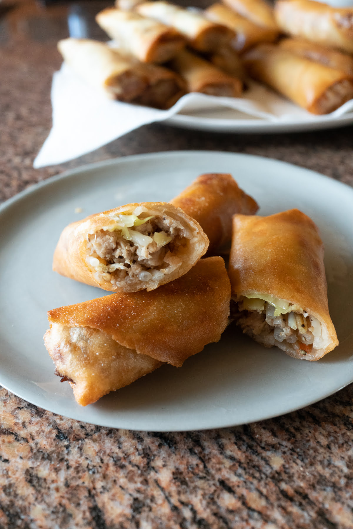 Freshly fried lumpia, cut in half and plated.