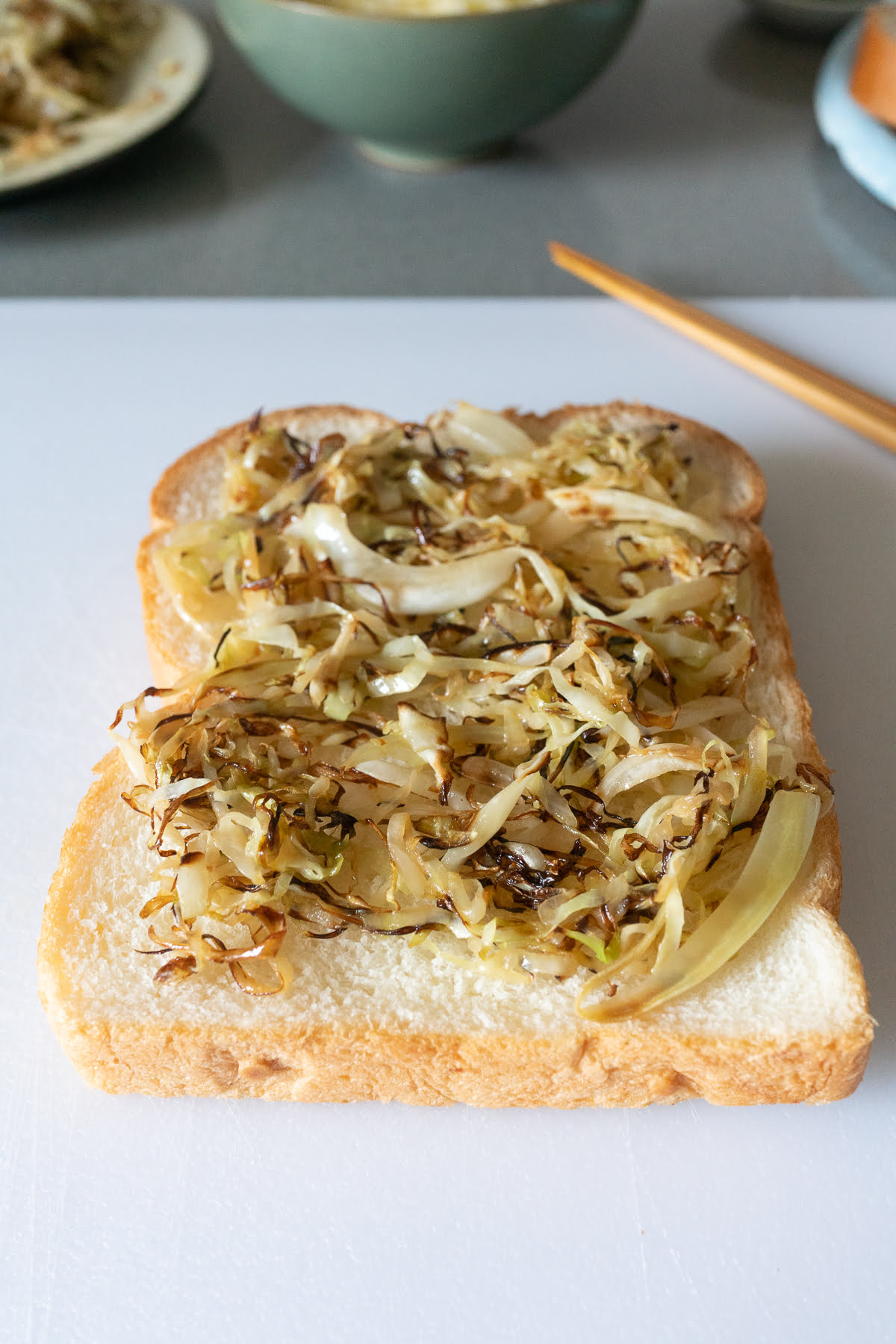 Putting the cabbage on the slice of bread.