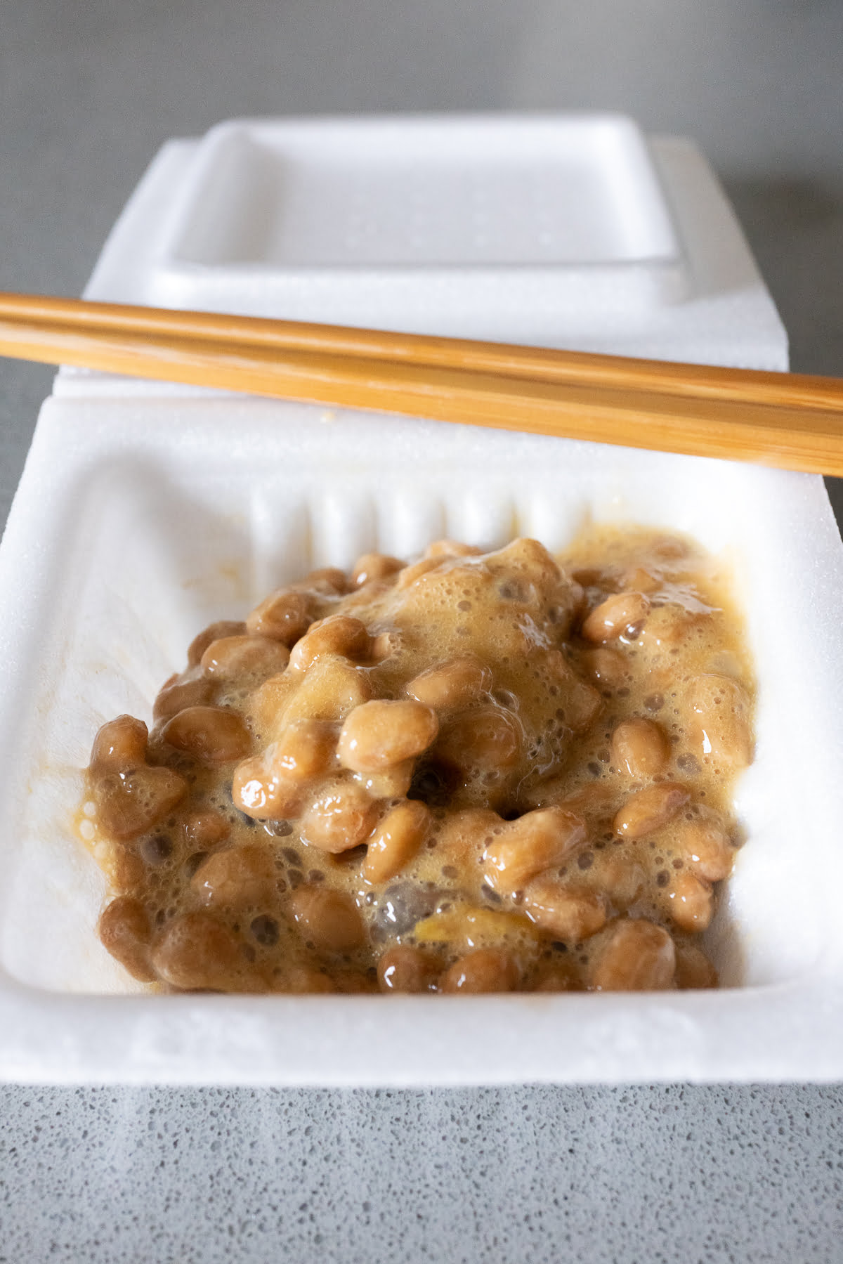A container of natto, just mixed with the soy sauce and mustard packets.