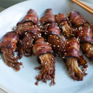 A plate of bacon wrapped enoki mushrooms.