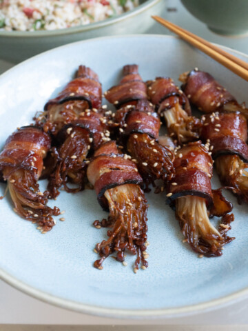 A plate of bacon wrapped enoki mushrooms.