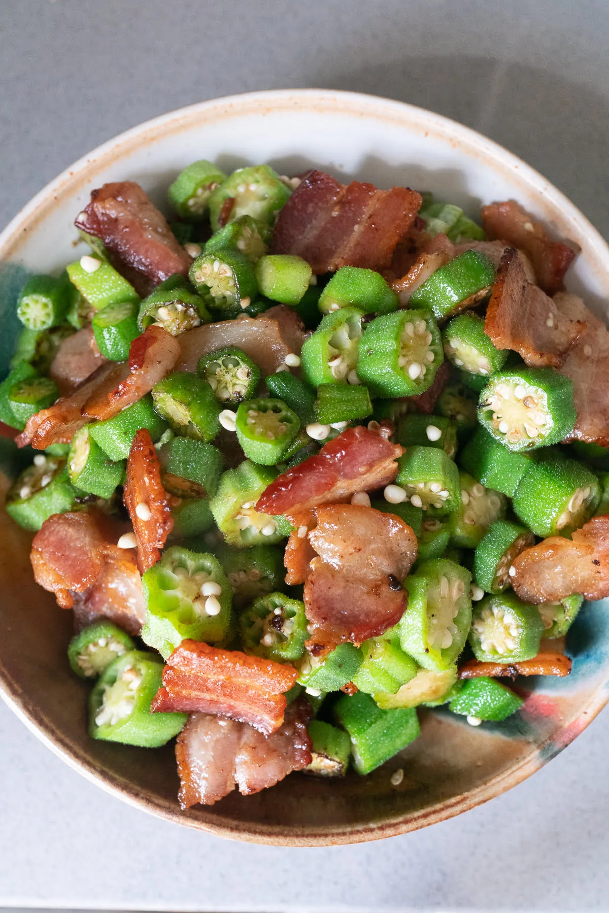 A bowl of stir fried okra and bacon.