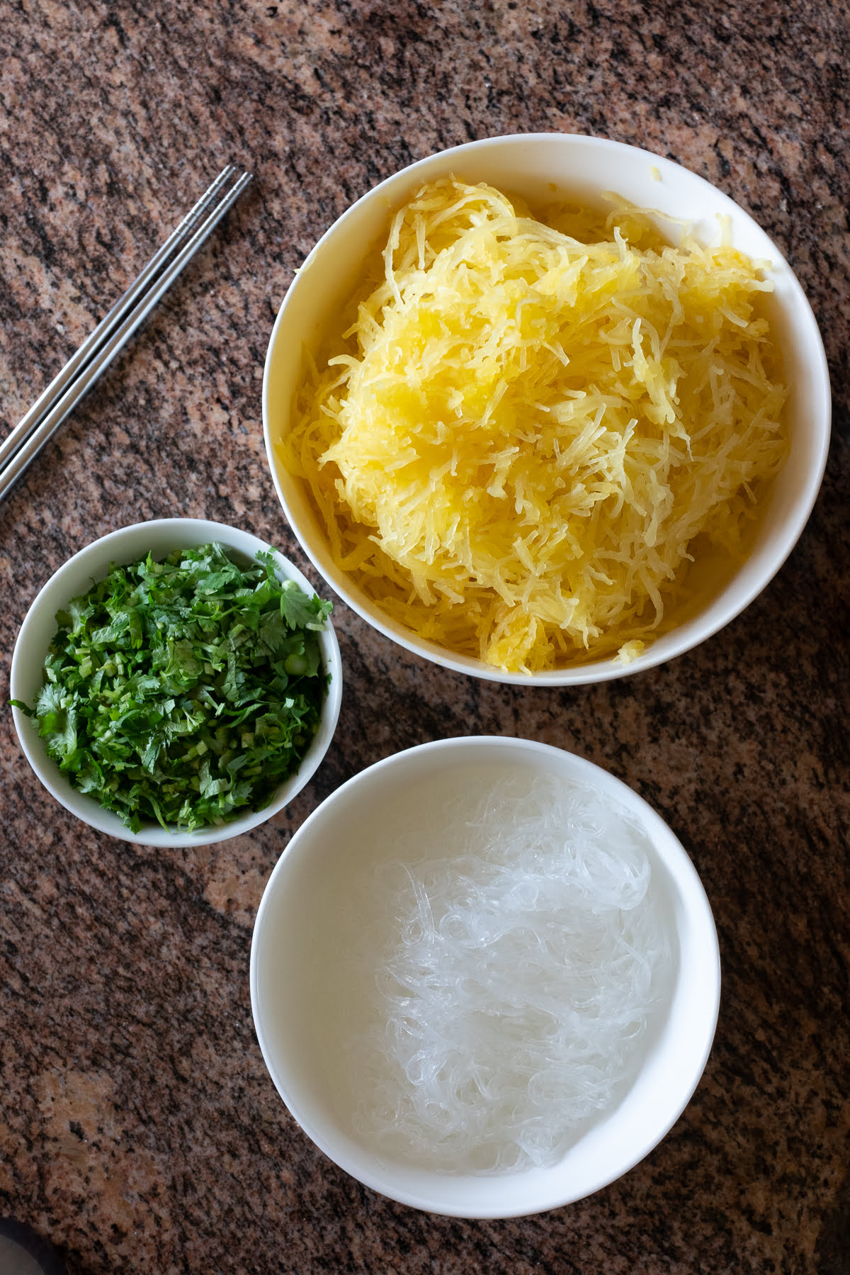 Bowls of roasted spaghetti squash, glass noodles, and cilantro.