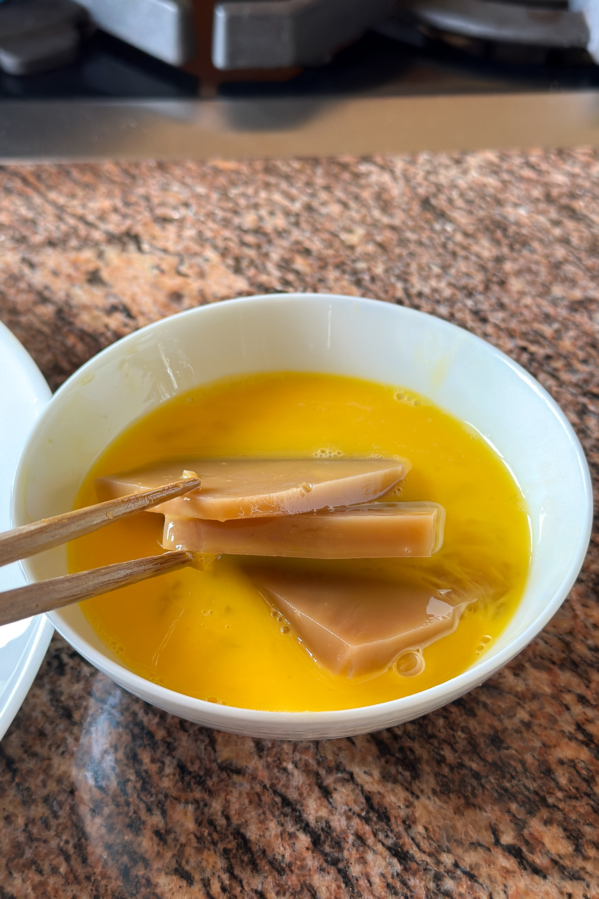 Dipping the nian gao slices in egg.