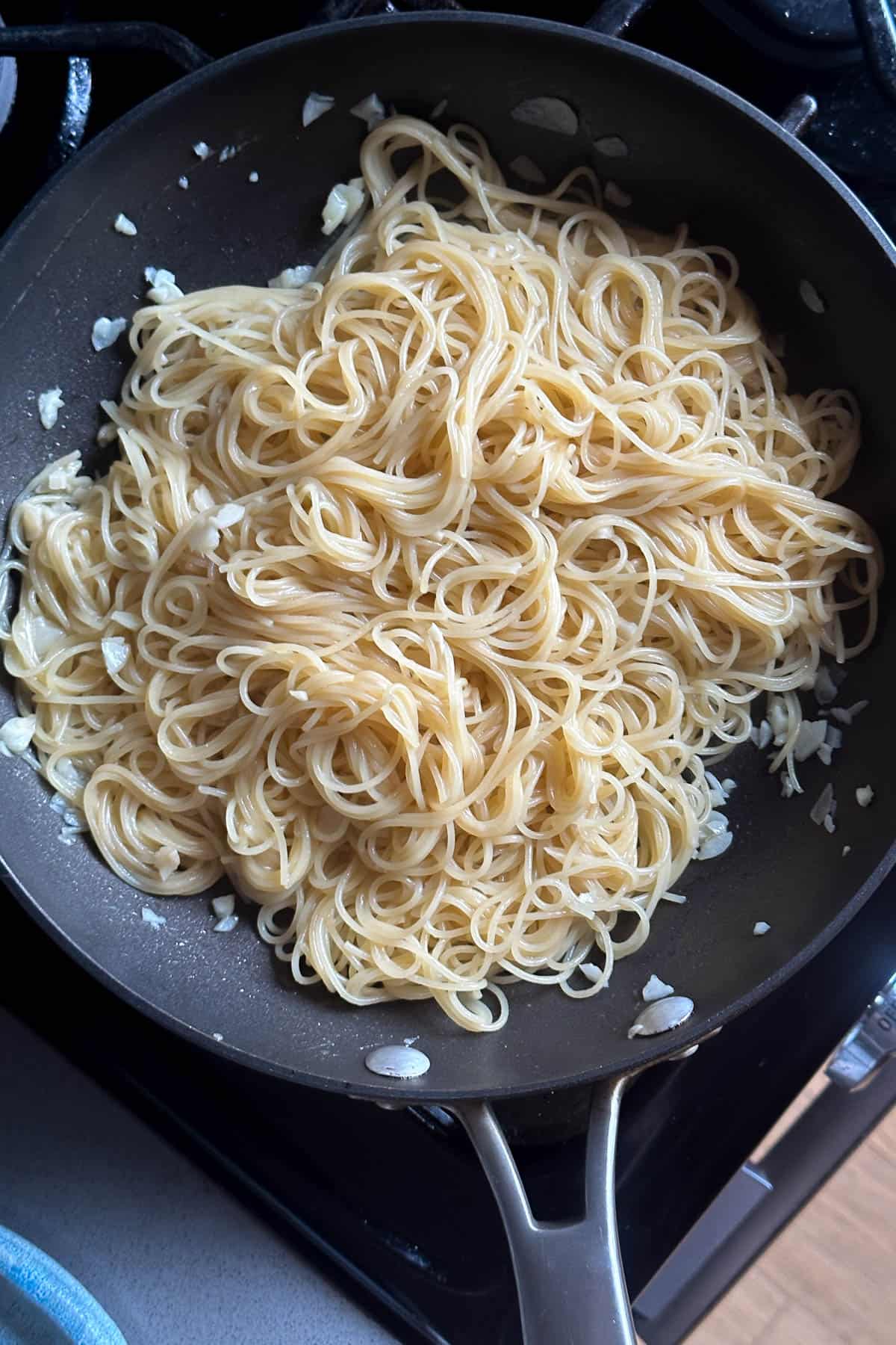 Cooking the angel hair pasta in the garlic and butter soy sauce mixture.