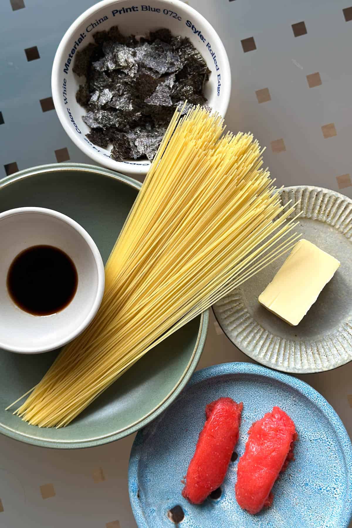 Ingredients for Mentaiko Pasta laid out on a table (angel hair pasta, mentaiko, soy sauce, butter, and nori).