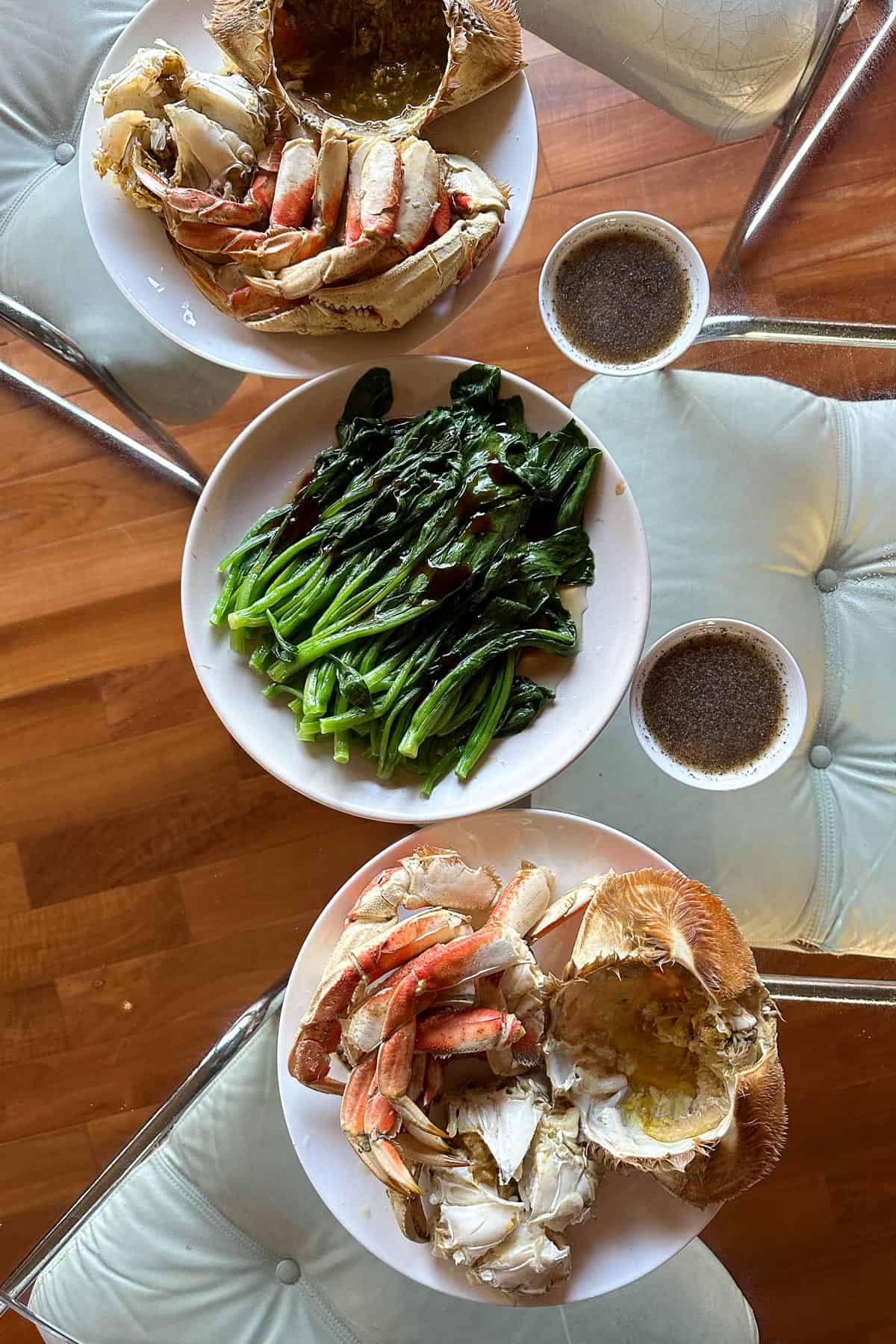 Serving fresh steamed Dungeness crabs with lemon pepper sauce and a side of choy sum.