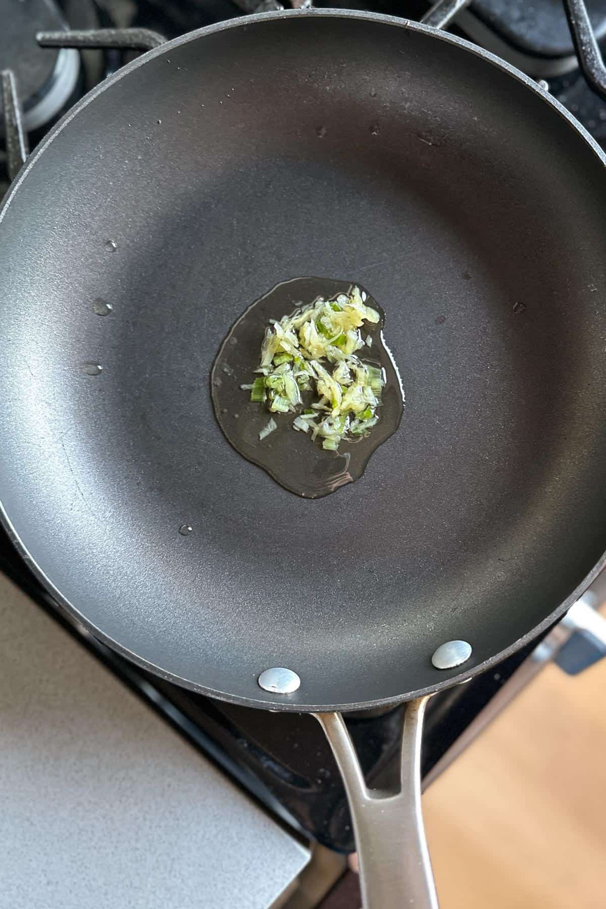 Heating ginger scallion sauce in a pan.