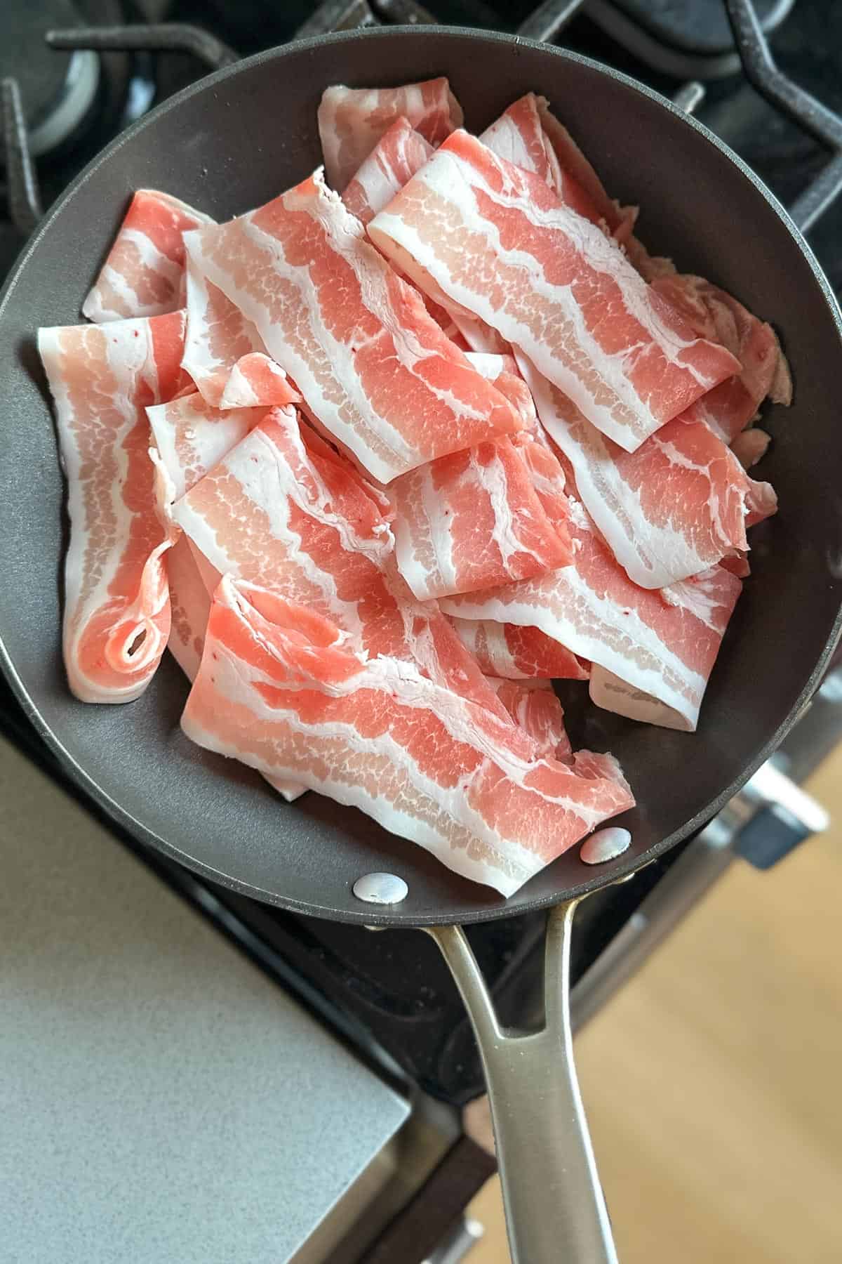 Adding pork belly to a pan.