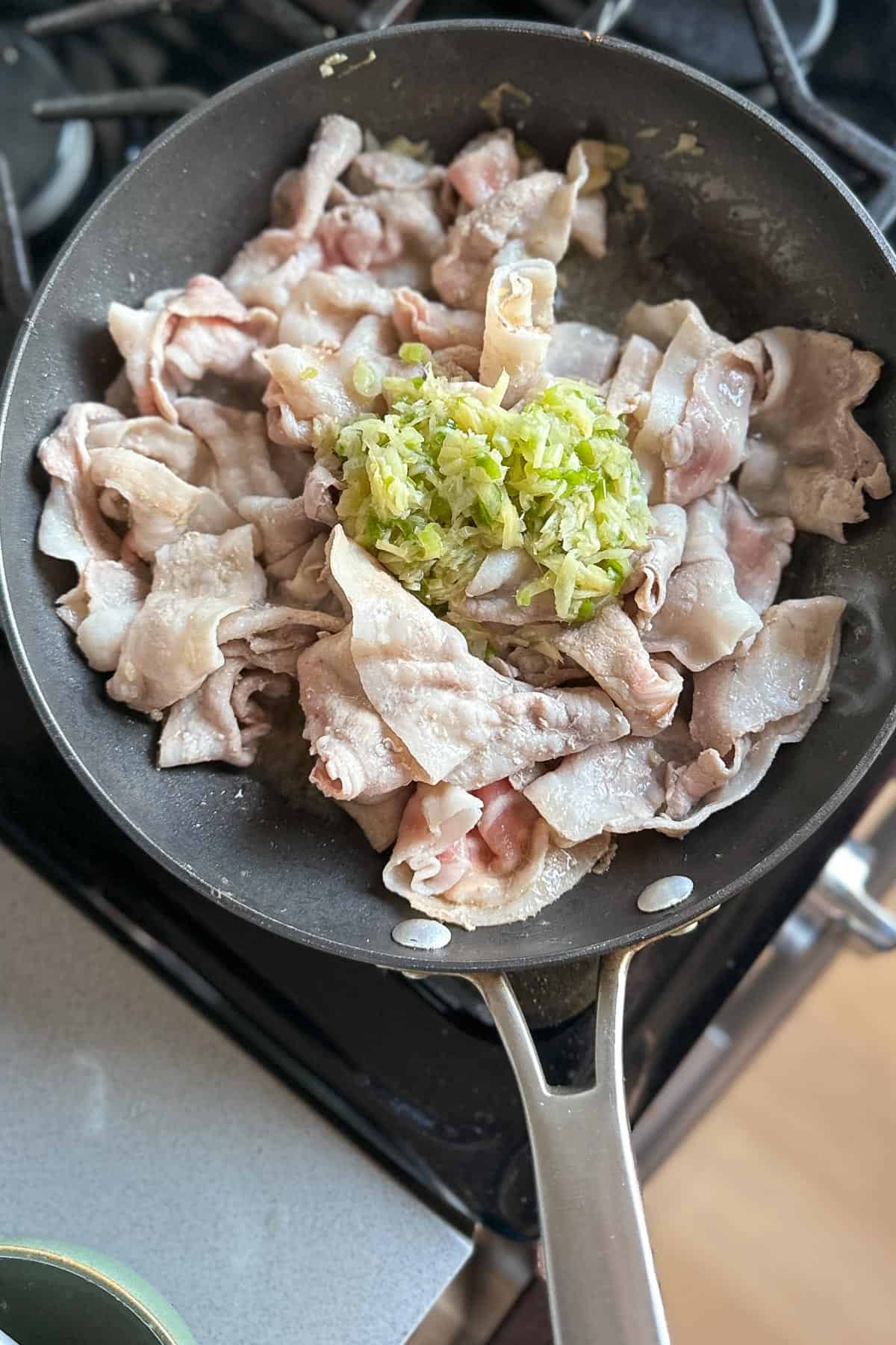 Cooking the pork belly and ginger scallion sauce together.