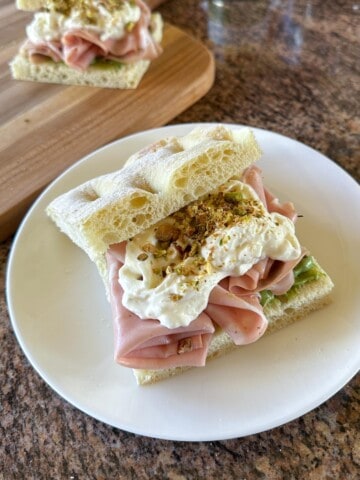 A mortadella sandwich with stracciatella and pistachios.