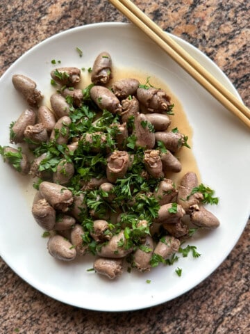 Pan fried chicken hearts topped with parsley.