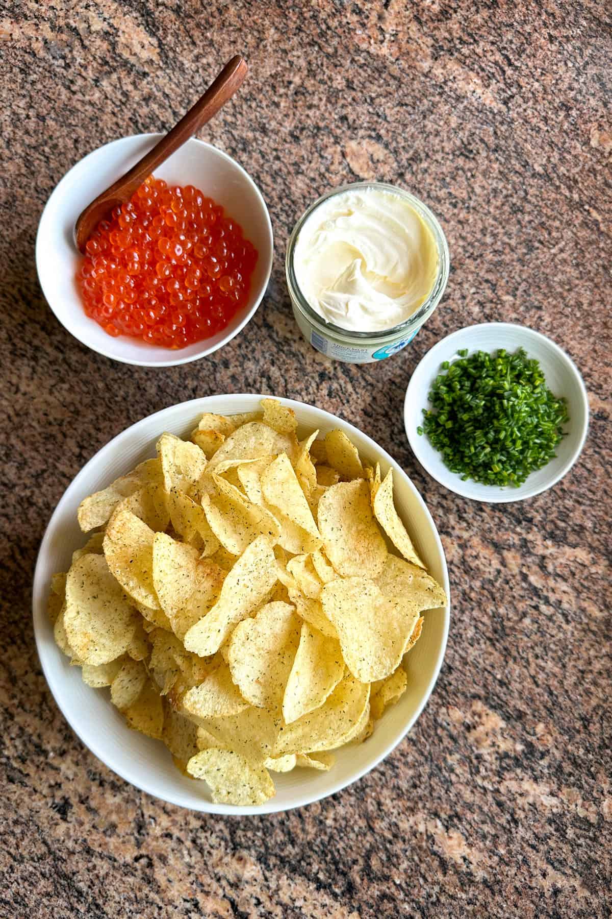 Ikura (salmon roe) with crème fraîche, chips, and chives.