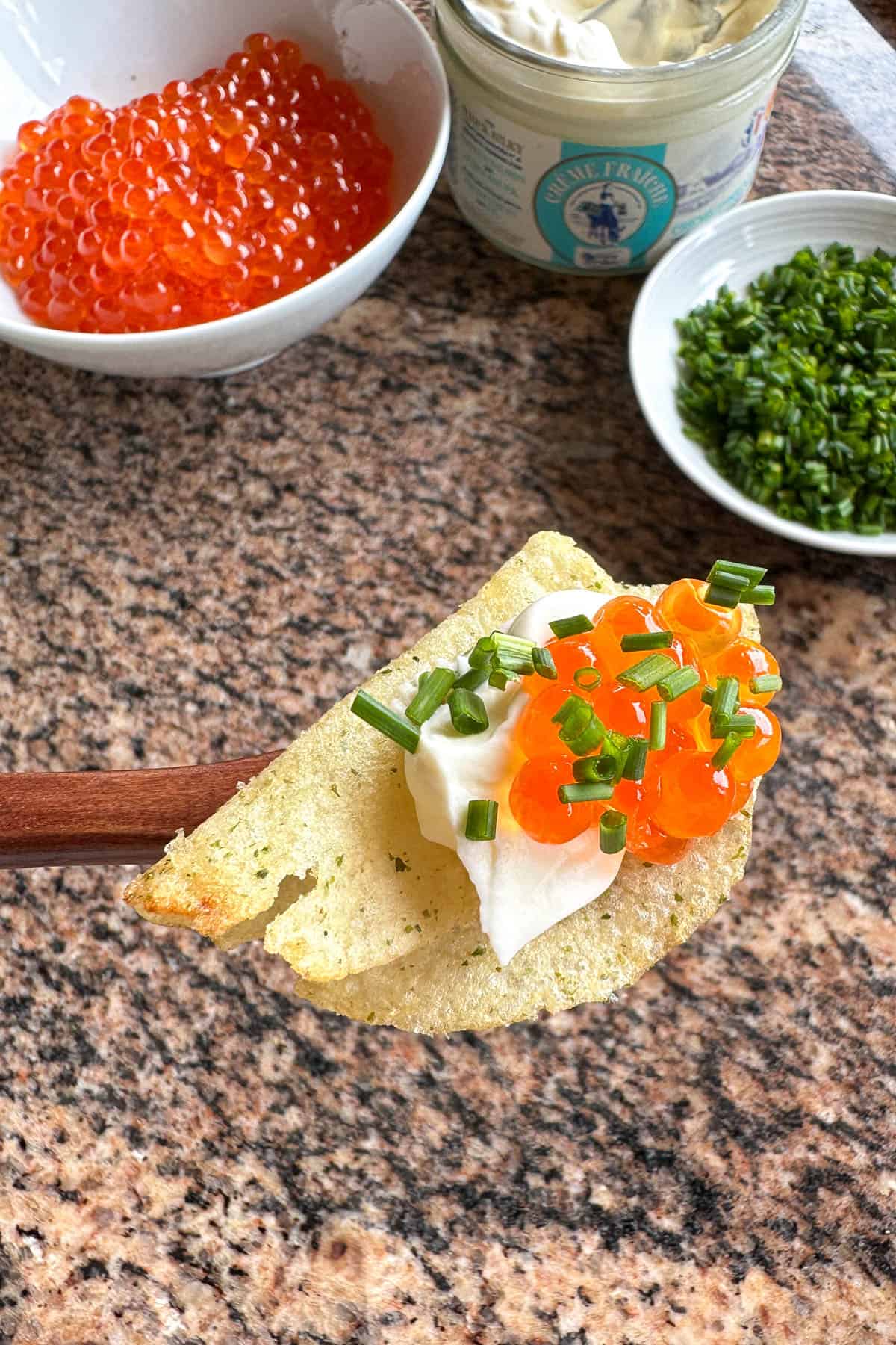 Chips topped with crème fraîche, ikura (salmon roe), and chives.