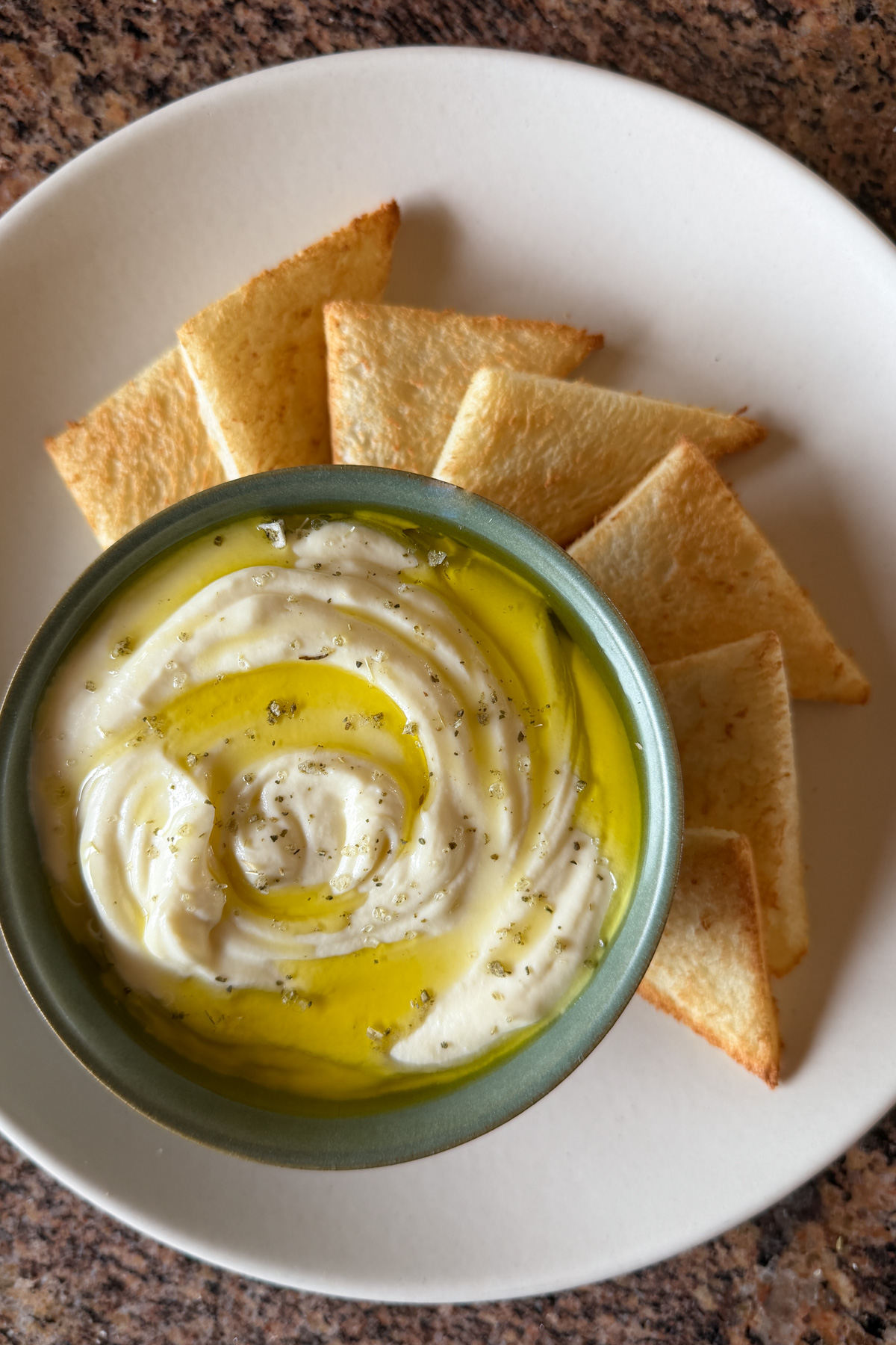 A bowl of whipped ricotta served with toast points on the side.